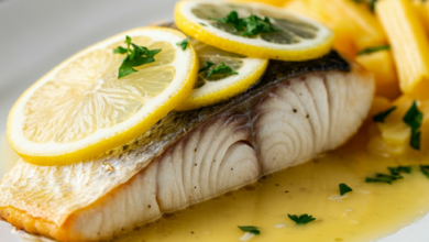 A beautifully plated Mahi Mahi fillet topped with lemon garlic butter sauce, garnished with lemon wedges and parsley on a sleek, white plate. The sauce lightly pools around the fish, with a subtle shine to emphasize its richness.